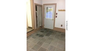 Mudroom with tile floors, closet with a curtain for a door, and back door