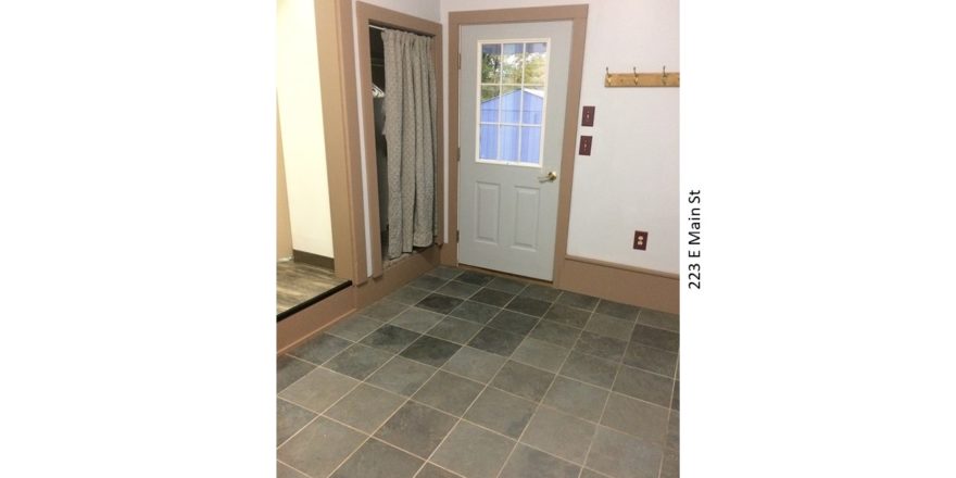 Mudroom with tile floors, closet with a curtain for a door, and back door