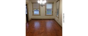 Unfurnished dining room with windows, chandelier, and hardwood floors