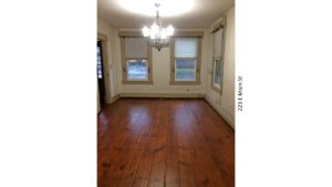 Unfurnished dining room with windows, chandelier, and hardwood floors