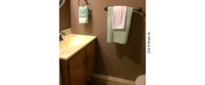 Small half-bathroom with vanity, mirror, and toilet
