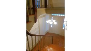 Entryway with wooden staircase, wood floors, and chandelier