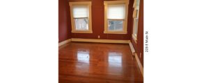 Room with hardwood floors, large windows, and ceiling fan
