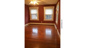 Room with hardwood floors, large windows, and ceiling fan