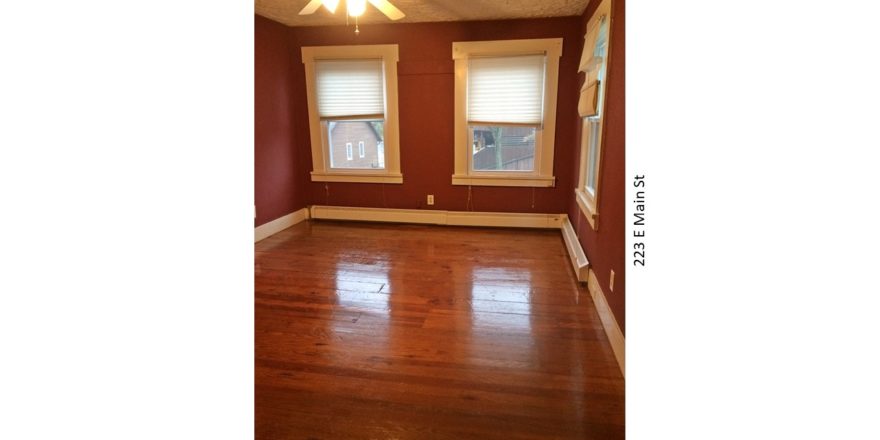 Room with hardwood floors, large windows, and ceiling fan