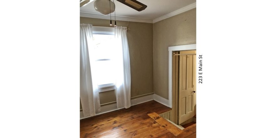 Room with steps up into it, ceiling fan, hardwood floors and window