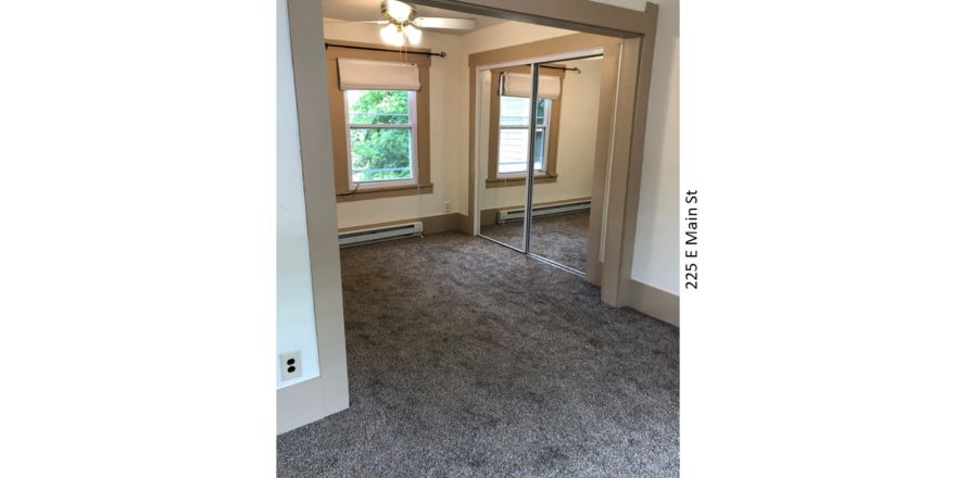 Bedroom with carpet, ceiling fan with a light, closet with mirror doors, and window