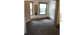 Unfurnished, carpeted bedroom with two windows