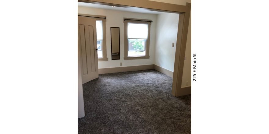 Unfurnished, carpeted bedroom with two windows