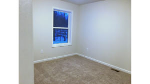 Unfurnished bedroom with tan carpet.