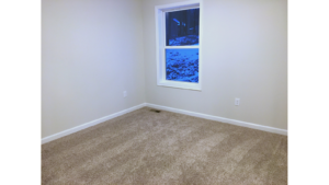 Unfurnished bedroom with tan carpet.