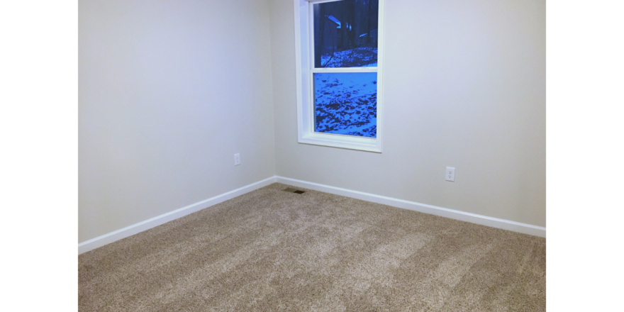 Unfurnished bedroom with tan carpet.