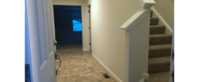 Entry way with tile-style laminate floor and carpeted stairs to the second floor.