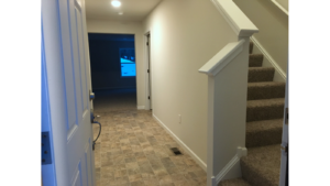 Entry way with tile-style laminate floor and carpeted stairs to the second floor.