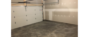 Empty garage with large door and cement floor