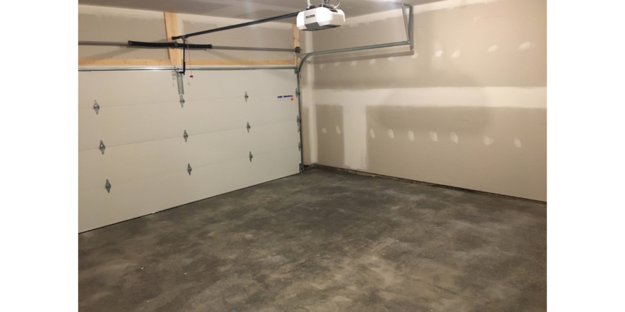 Empty garage with large door and cement floor