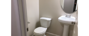 Half-bathroom with toilet and pedestal sink