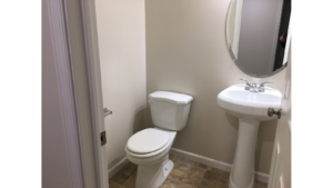 Half-bathroom with toilet and pedestal sink
