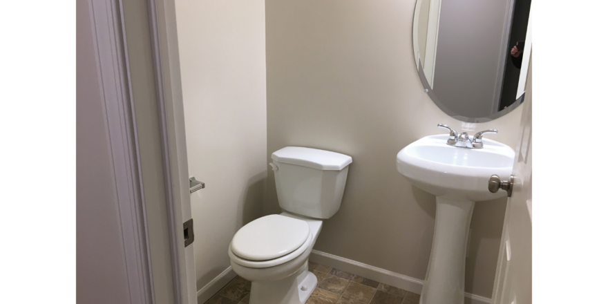 Half-bathroom with toilet and pedestal sink