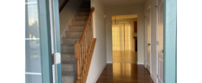 a hallway leading to a second story with wood floors