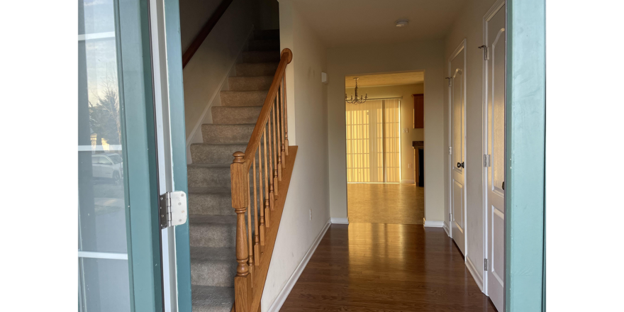 a hallway leading to a second story with wood floors