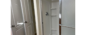 a bathroom with a walk in shower next to two doors