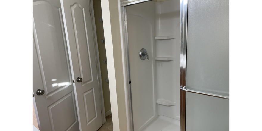 a bathroom with a walk in shower next to two doors