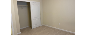 an empty room with a closet and white door