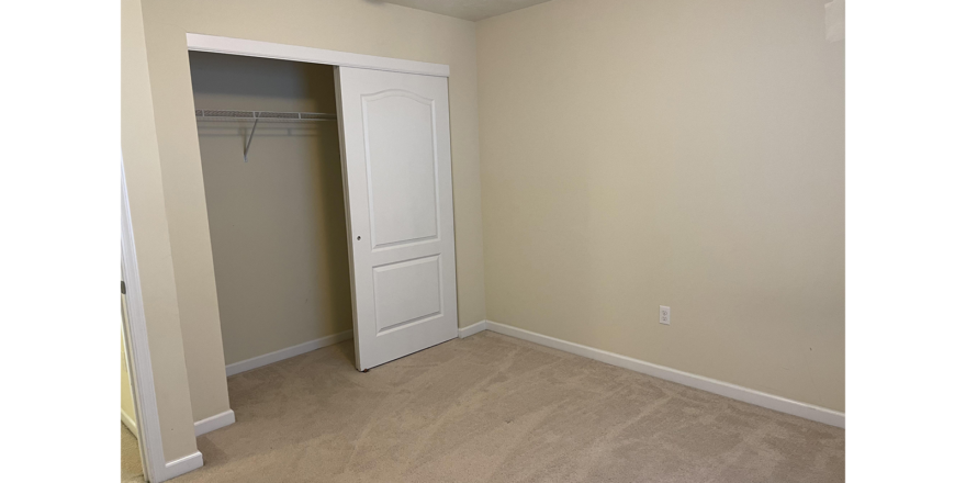 an empty room with a closet and white door