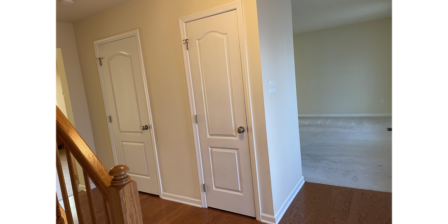 three white doors in a room with hardwood floors