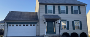 a two story house with green shutters and a white garage