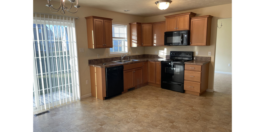 a kitchen with black appliances and wooden cabinets