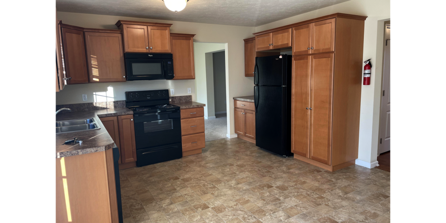 a kitchen with black appliances and wooden cabinets