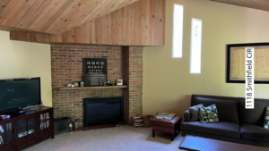 a living room filled with furniture and a flat screen tv and fireplace