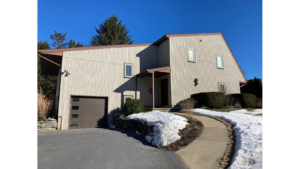 Modern house with crank windows and tan, vertical siding