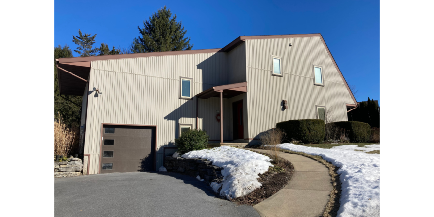 Modern house with crank windows and tan, vertical siding