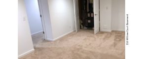 Basement room, carpeted with beige carpet, doorway on the left, closet ahead