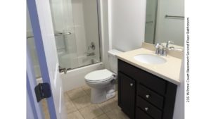 Bathroom with vanity, mirror, toilet, and tub/shower combo with sliding glass door