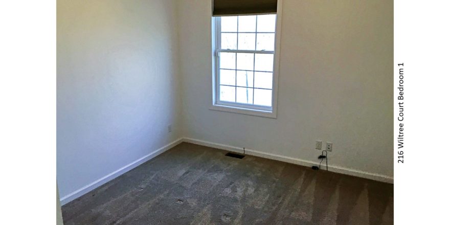 Unfurnished, carpeted bedroom with window