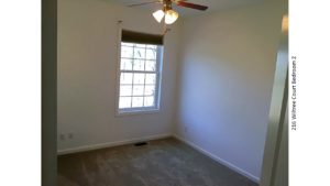 Unfurnished, carpeted bedroom with window and ceiling fan