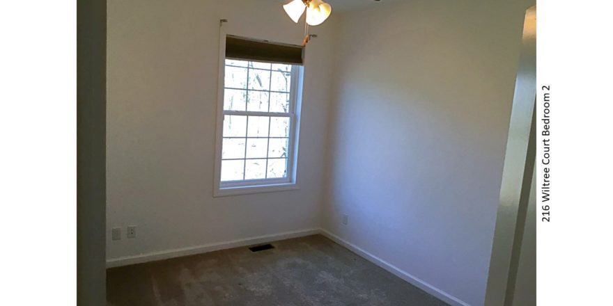 Unfurnished, carpeted bedroom with window and ceiling fan