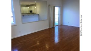 Dining area with hardwood floors, large mirror, and sliding glass door