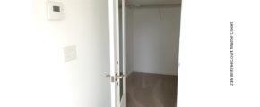 Carpeted walk in closet with white wire shelving and clothes rods