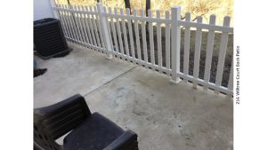 Concrete patio with white picket fence