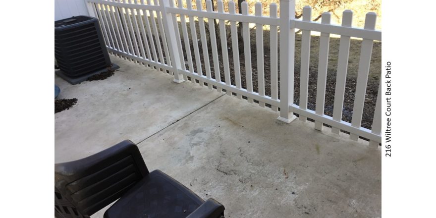 Concrete patio with white picket fence