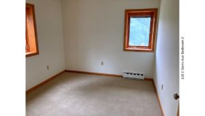 Unfurnished and carpeted bedroom with crank windows