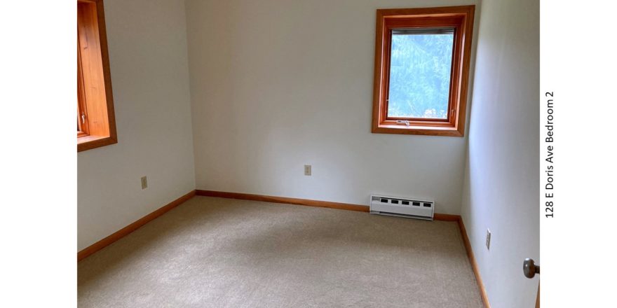 Unfurnished and carpeted bedroom with crank windows