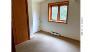 Unfurnished and carpeted bedroom with closet and crank windows