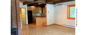 Dining area with wood-burning stove, light wood-style parkay flooring, fire extinguisher, and wood beams with track lighting