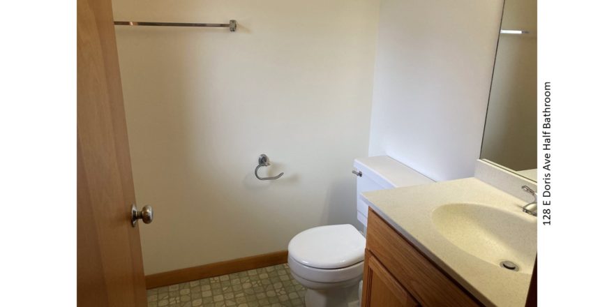 Half-bathroom with toilet and vanity and mirror